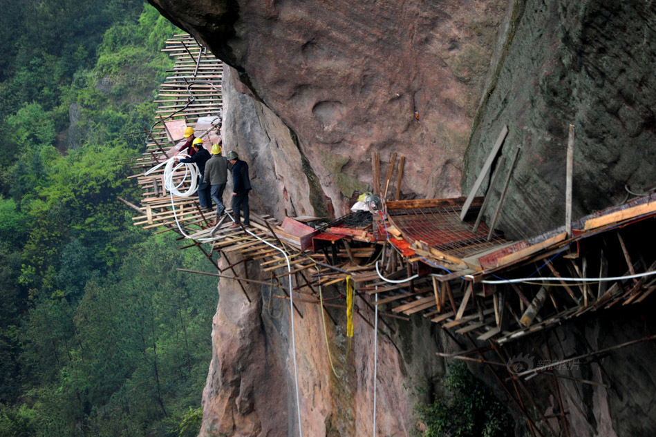PHOTOS: No ropes or harnesses for these daring workers, building cliff path one step at a time